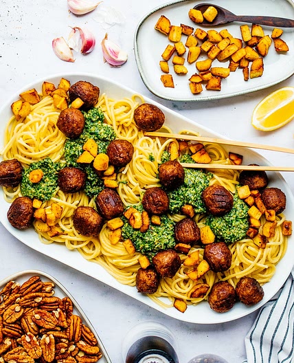 Spaghetti mit Rucola-Pesto, pflanzlichen Bällchen & knusprigen Pastinakenstückchen
