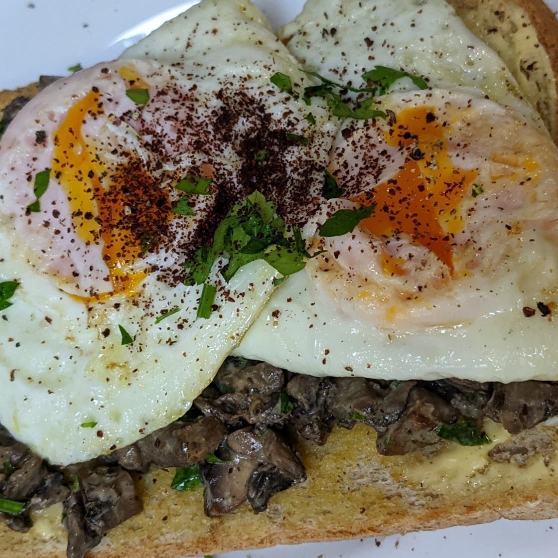 Creamy mushrooms, fried eggs on toast