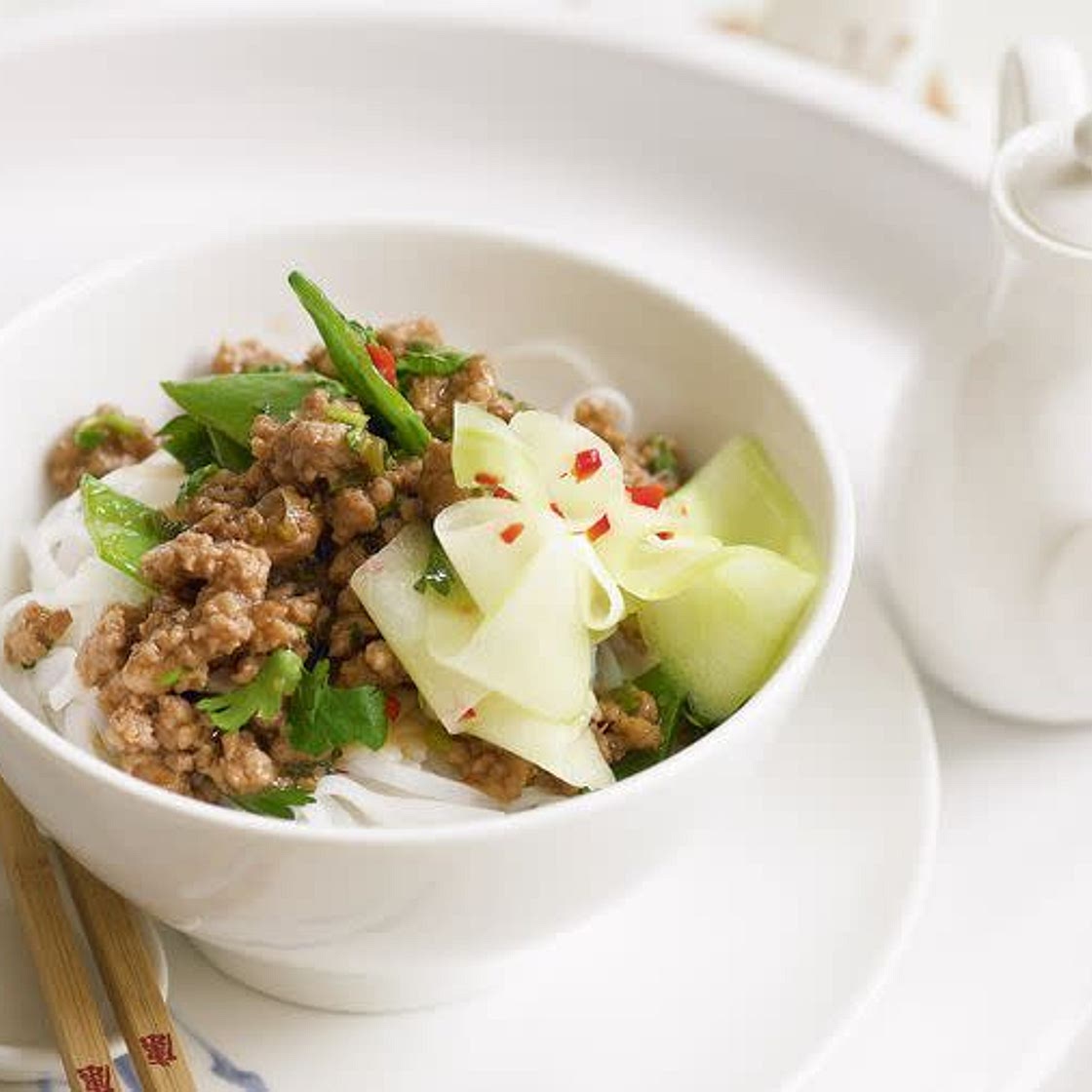 Stir-fried pork and pickled cucumber on rice noodles