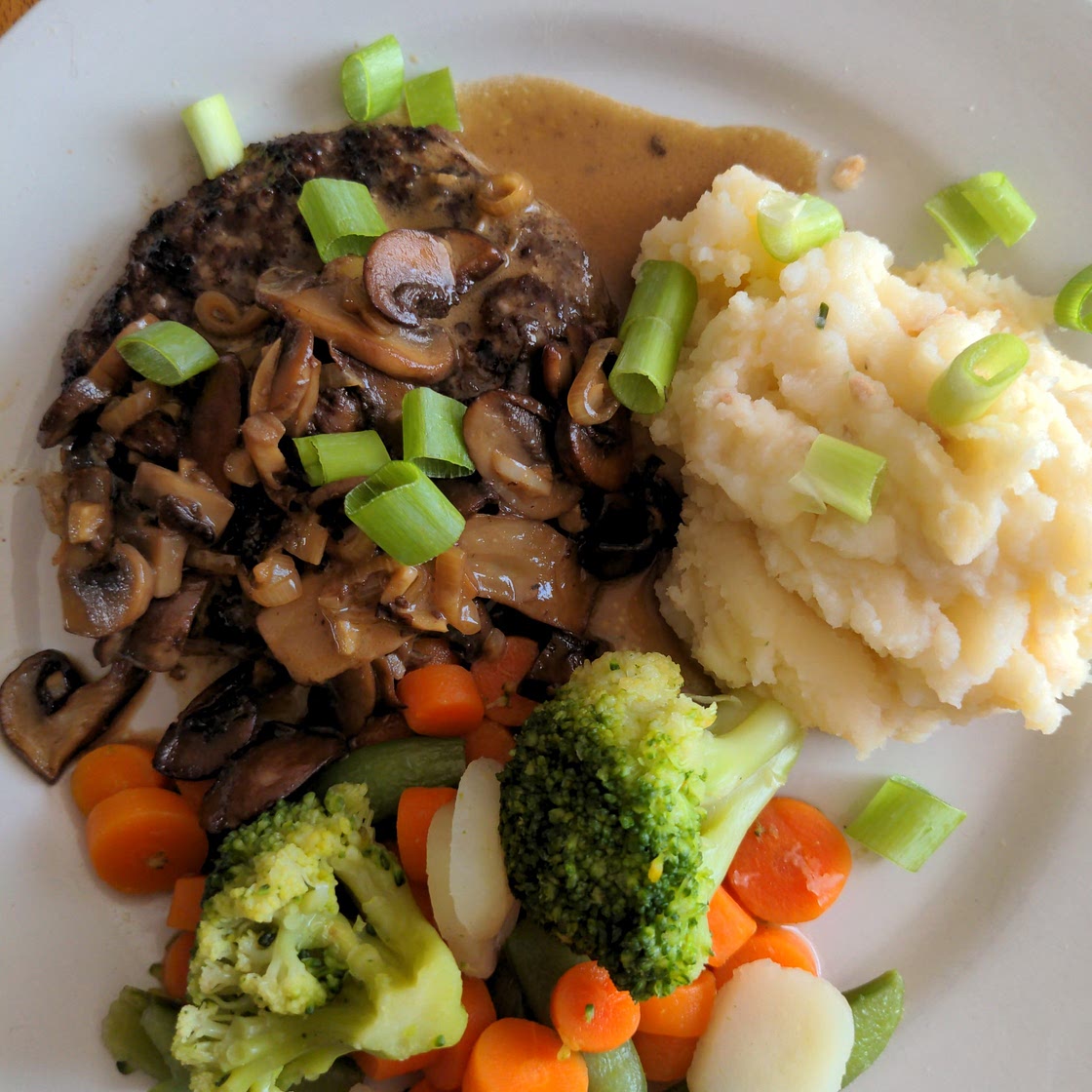 Angus Steakhouse Patty with Mushroom Cream Sauce, Loaded Mashed Potatoes, and Mixed Veg