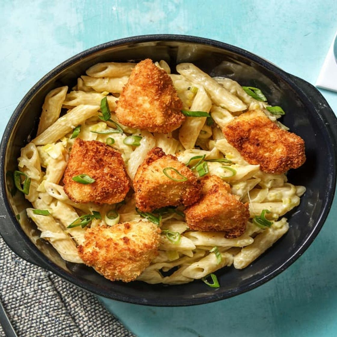 Selbst gemachte Hähnchen-Nuggets auf cremiger Curry-Lauch-Pasta