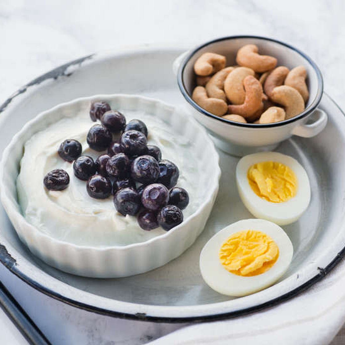 Breakfast bento with yogurt, egg, blueberries and cashews
