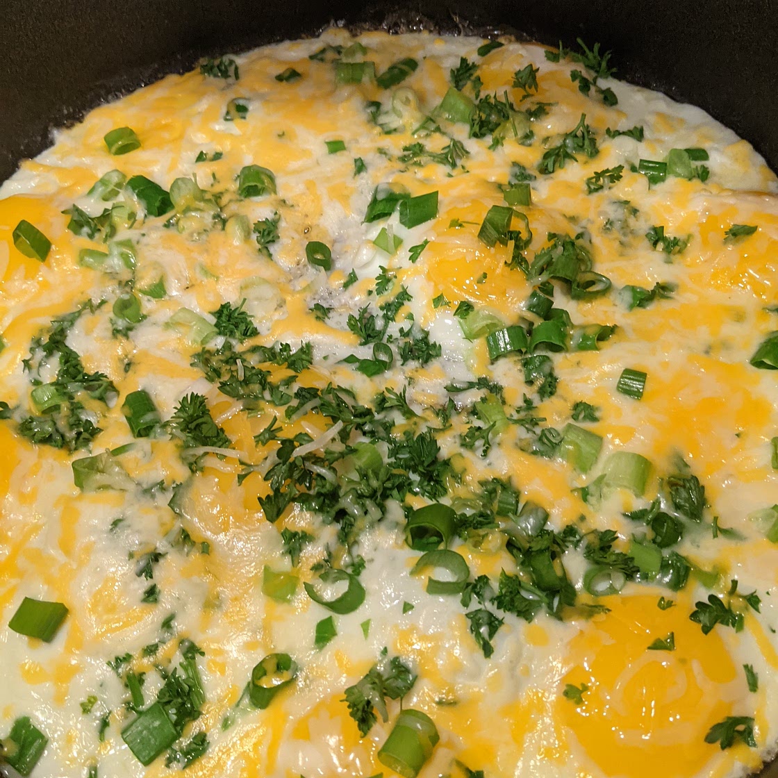 Fried eggs with green onions, parsley, & cheese