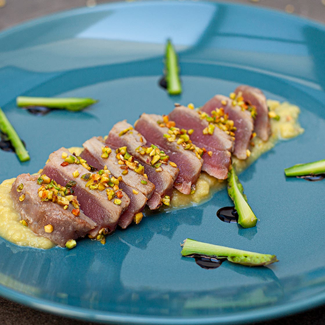 Tataki di tonno in crosta di pistacchi con crema di asparagi e germogli