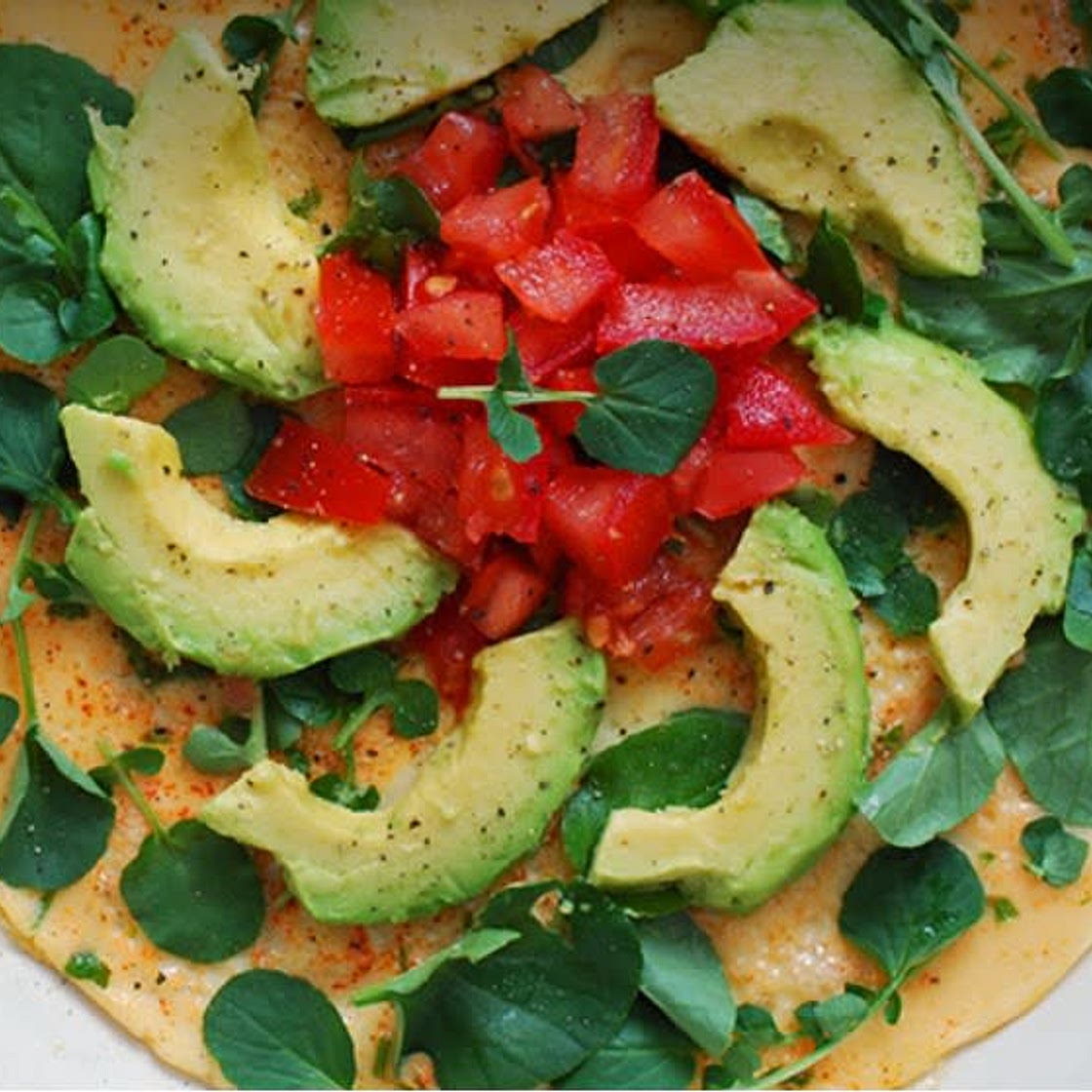 Tortilla a las finas hierbas con aguacate, tomate y berros.