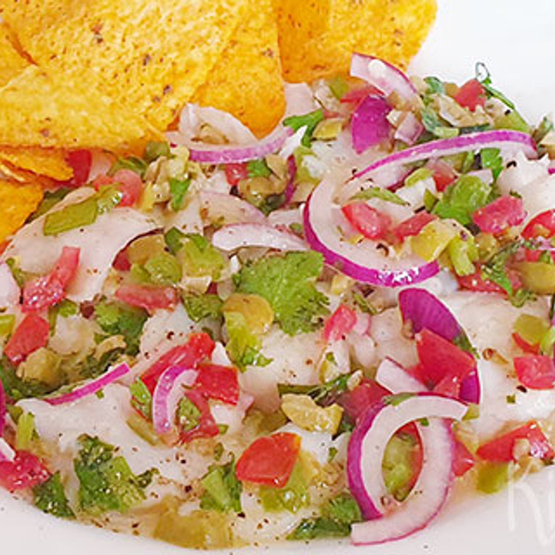 Ceviche van witvis met tomaat, olijven en groene pepers