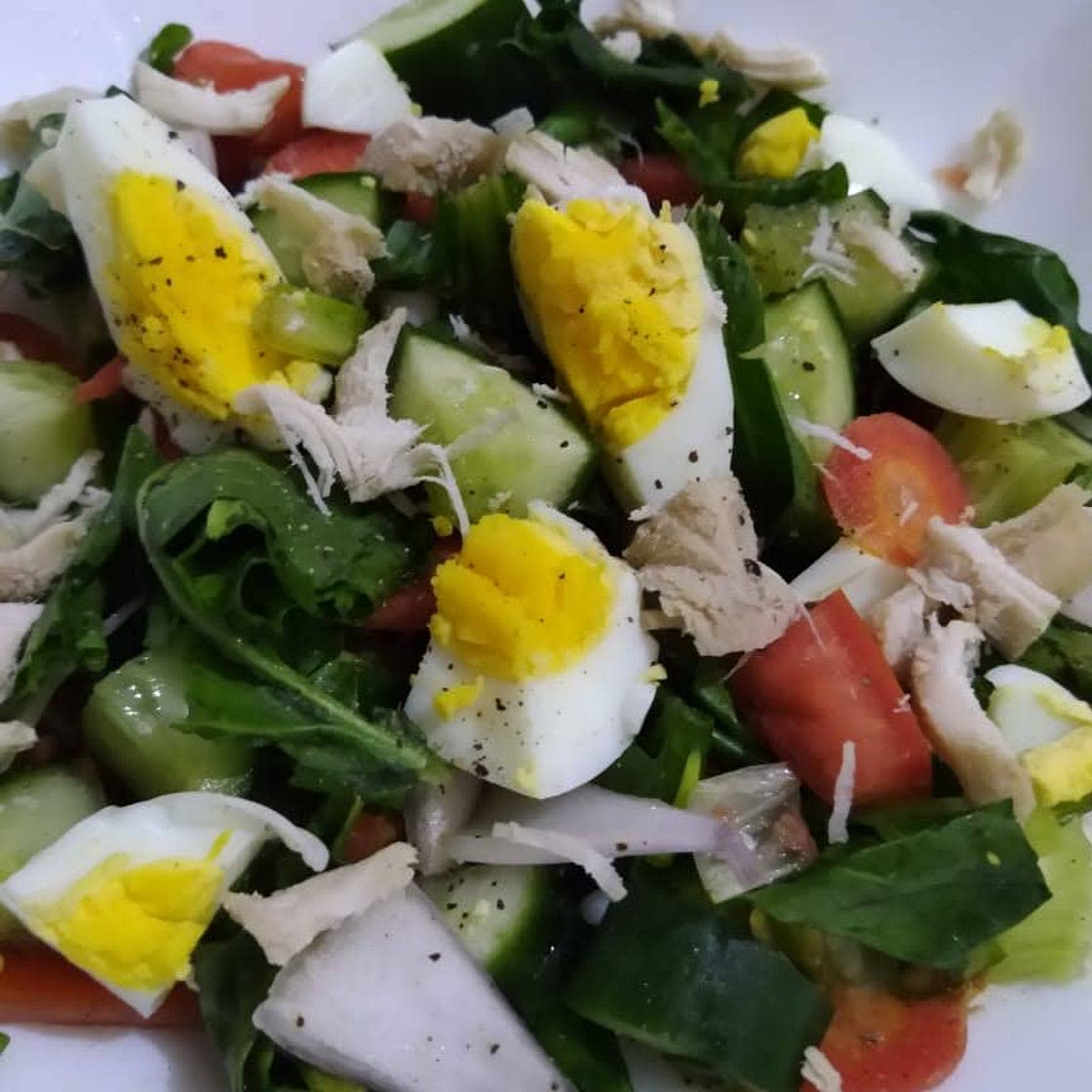 Greek salad with spinach, carrots and egg with chicken