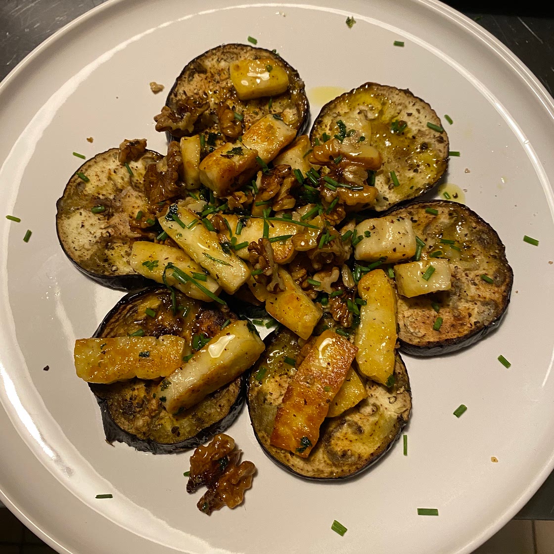Gebakken aubergine met halloumi, knoflook en noten