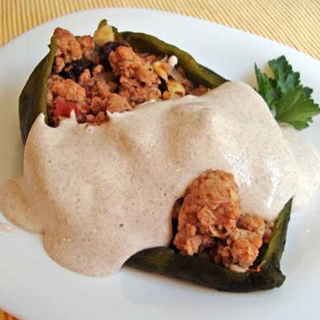 Chiles rellenos de picadillo bañados en salsa de chipotle.