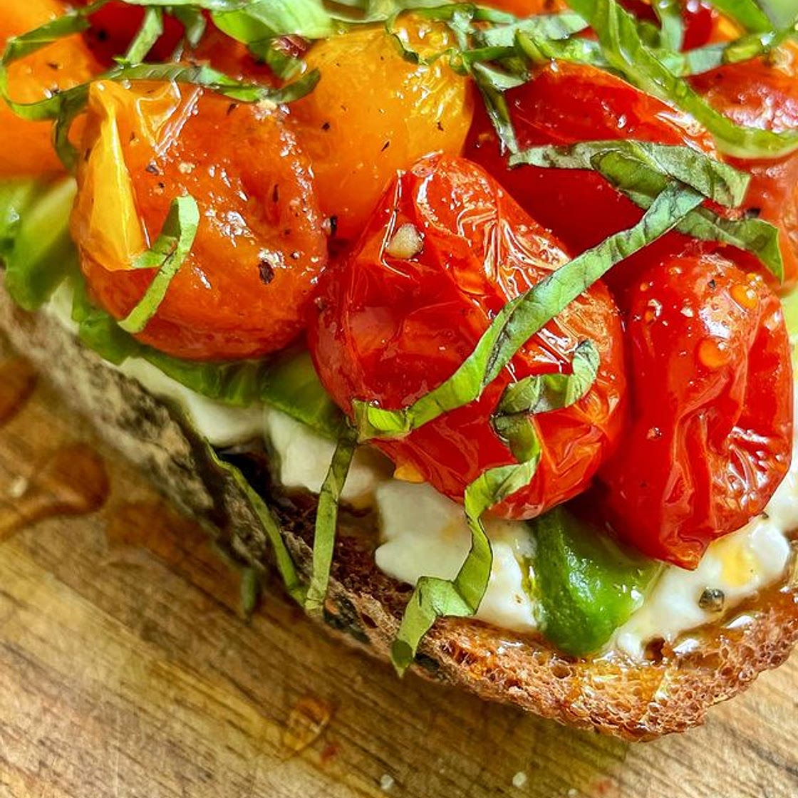 Happy Toast Tuesday ☺️☺️ ⠀ 1 slice sourdough 1 cup cherry tomatoes 2 tbsp olive oil 1/4 cup cottage cheese or ricotta 1/2 avocado, sliced 2-3 basil leaves, chopped Hot honey Salt and pepper 1. Preheat oven to 425°F. Place tomatoes in a ramekin, season with