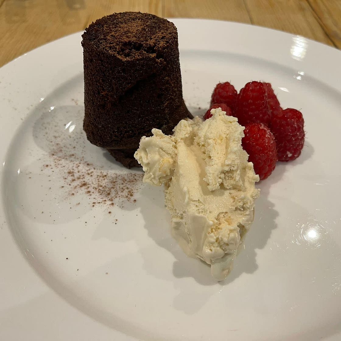 Chocolate fondant with fresh raspberries and vanilla ice cream/ fresh cream.