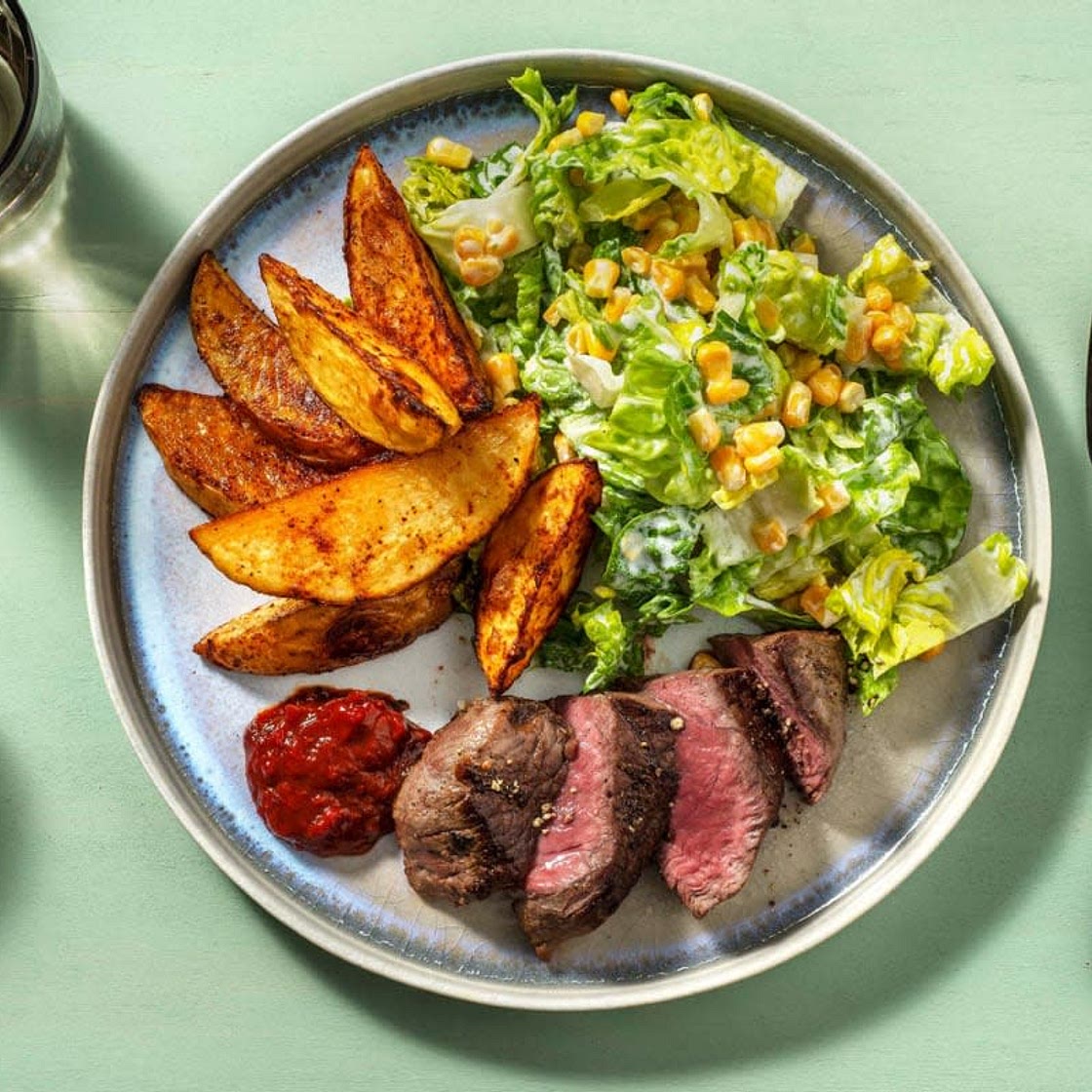 24 Rinderhüftsteak mit Kartoffelspalten, Pflaumenketchup und grünem Salat mit Mais