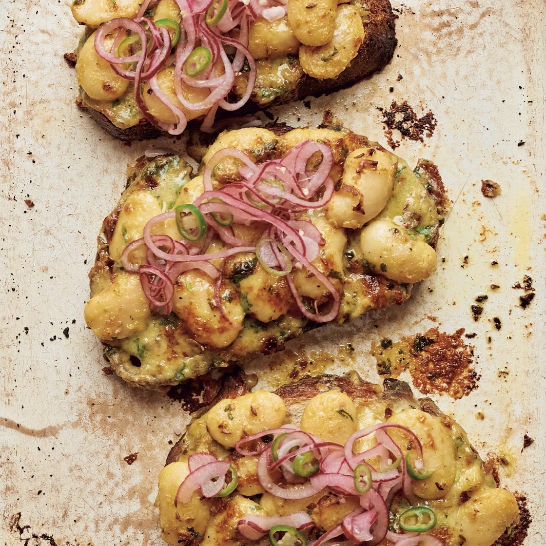 Cheesy curried butter beans on toast with pickled onion