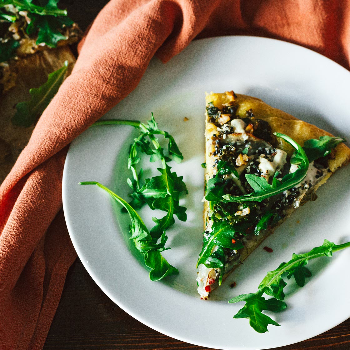 Crispy Seasoned Potato Pesto Pizza with Cashew Mozzarella Cream and Arugula on an Herbed Crust