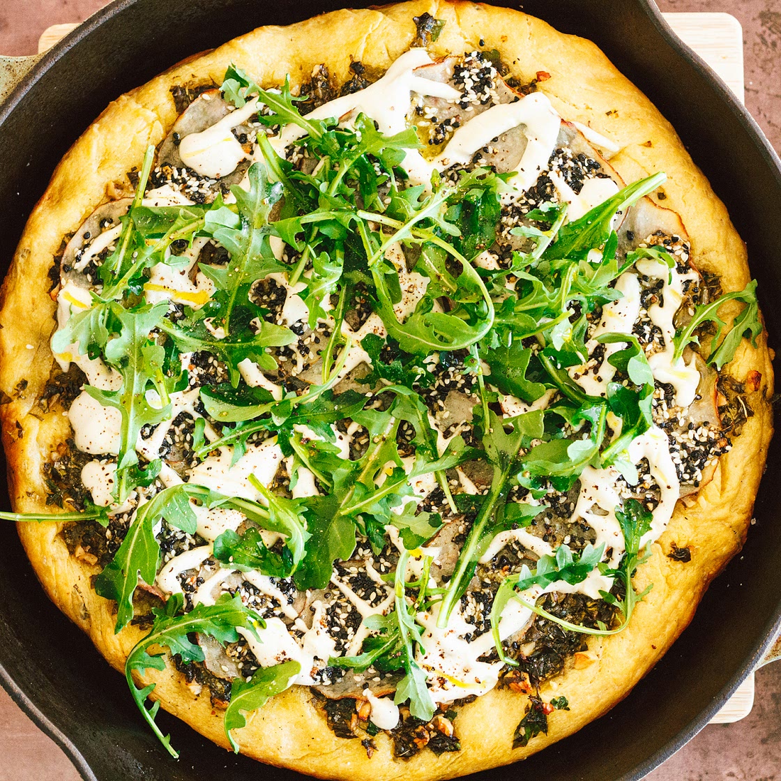 Crispy Seasoned Potato Pesto Pizza with Cashew Mozzarella Cream and Arugula on an Herbed Crust