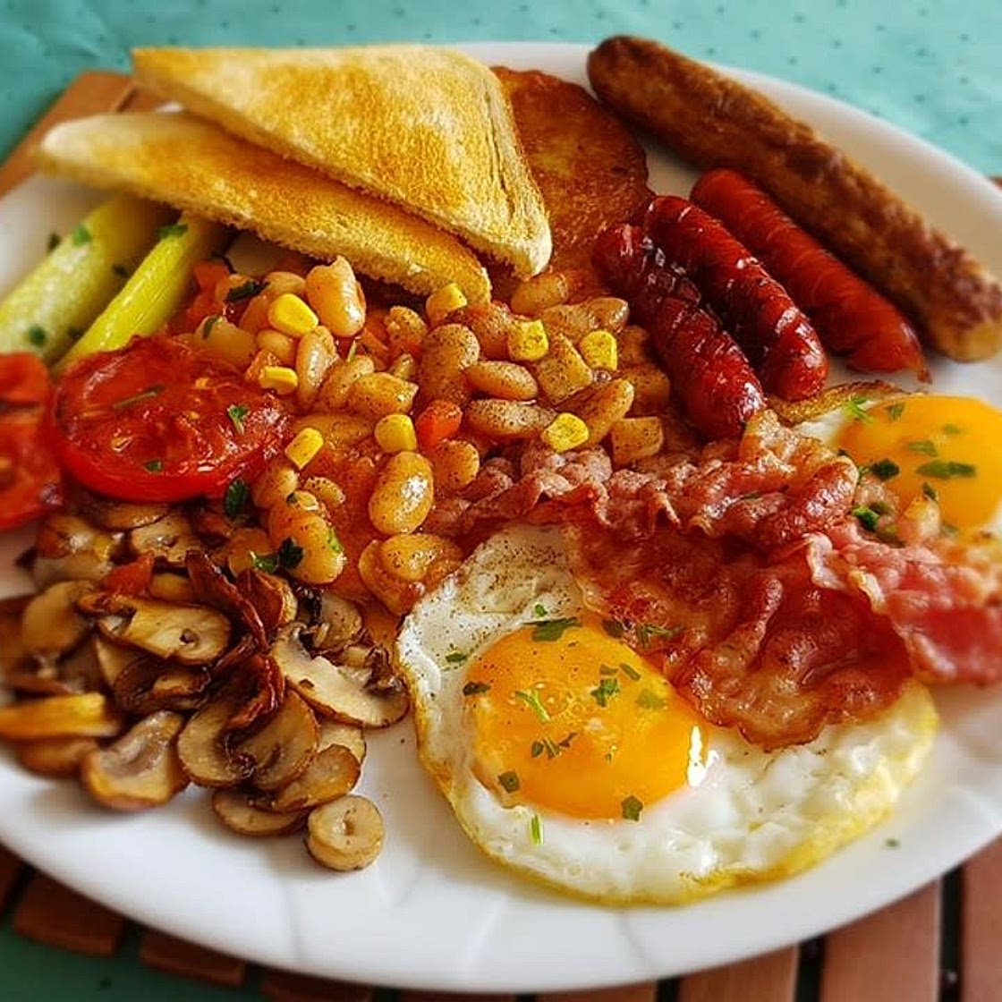 Herzhafte English Breakfast-Variante mit Vollkorntoast, Spiegelei, Baked Beans und Geflügelbratwurst