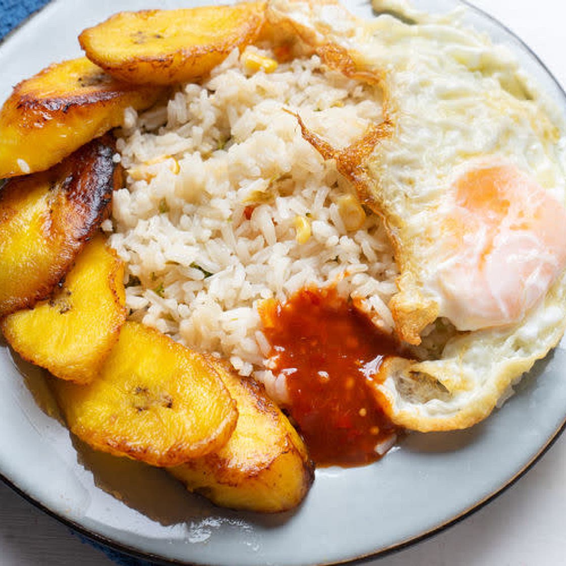Arroz con huevos y plátano frito