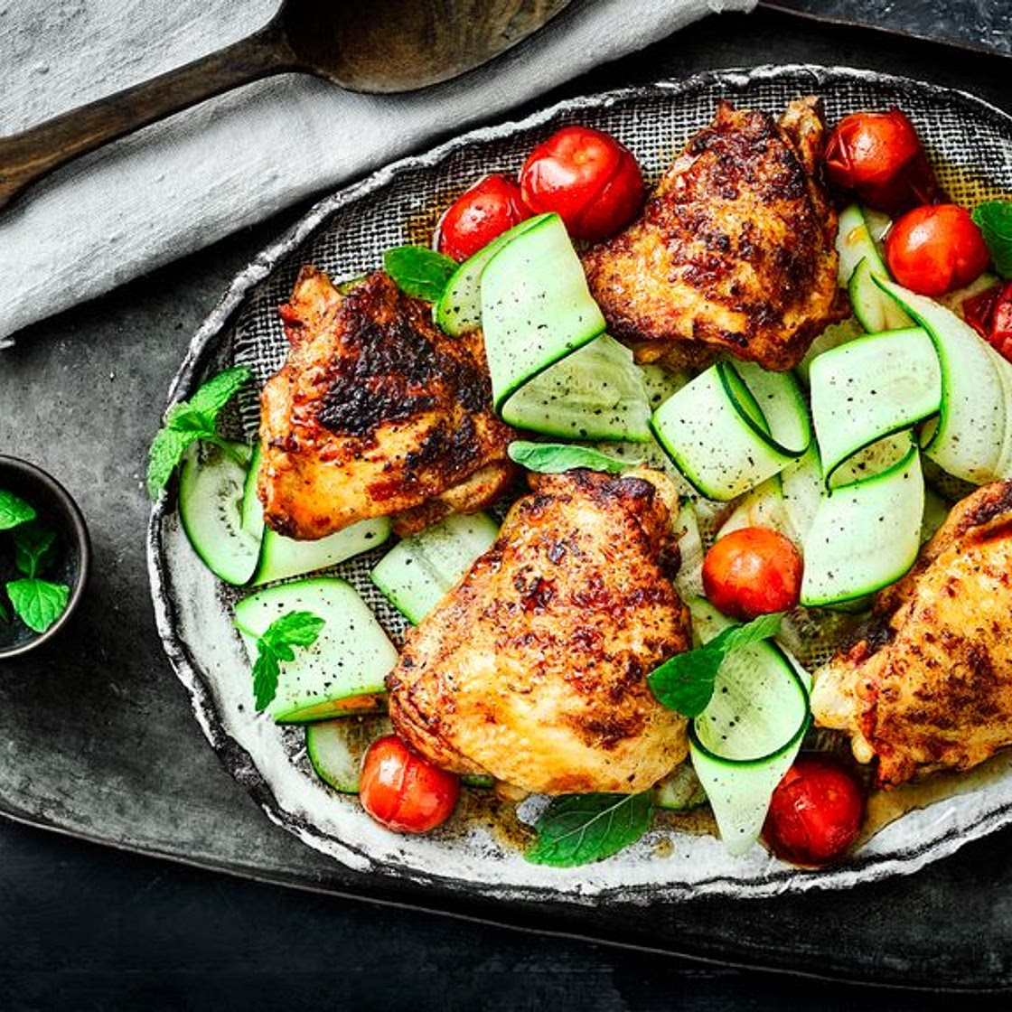 Paprika chicken thighs with cherry tomatoes, courgette ribbons and mint