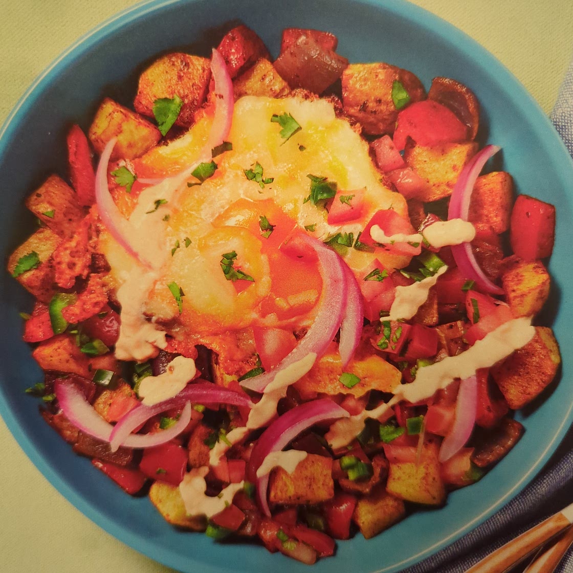 Cheesy fried eggs over nacho potato hash