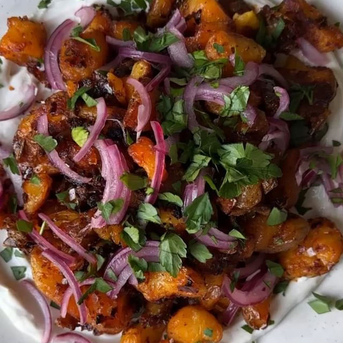 Crispy smashed harissa potatoes on a thick garlicky yoghurt