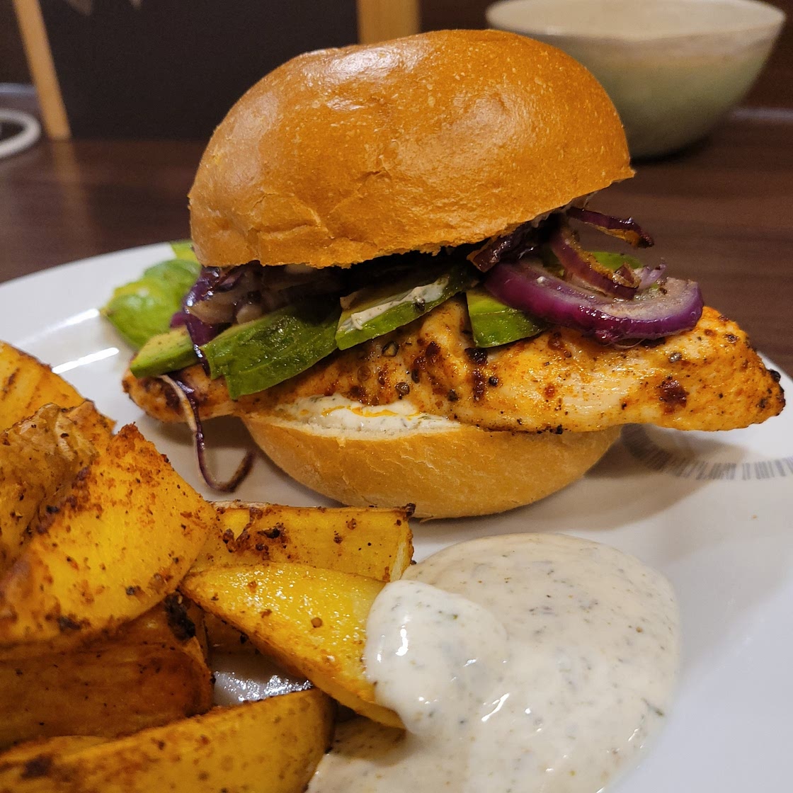 Harissa Chicken Burger! mit Zatar-Dip, Avocado roten Zwiebeln und würzigen Kartoffelspalten