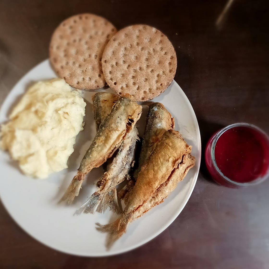Fried herrings with smashed potatoes and sauce of red fruits