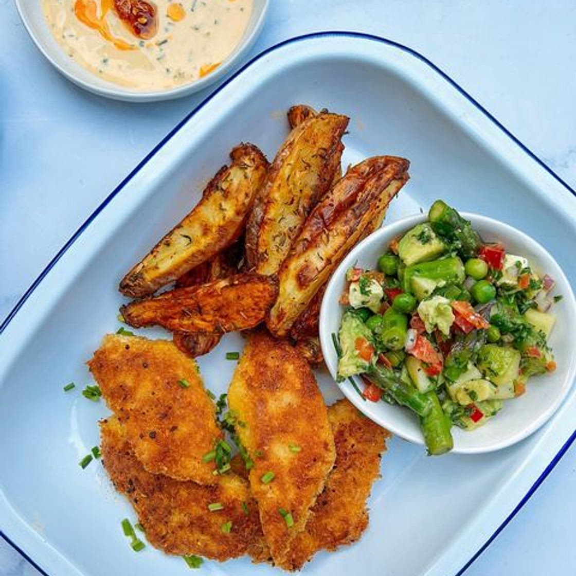 Crispy Parmesan panko fish with an asparagus pea avocado feta sa