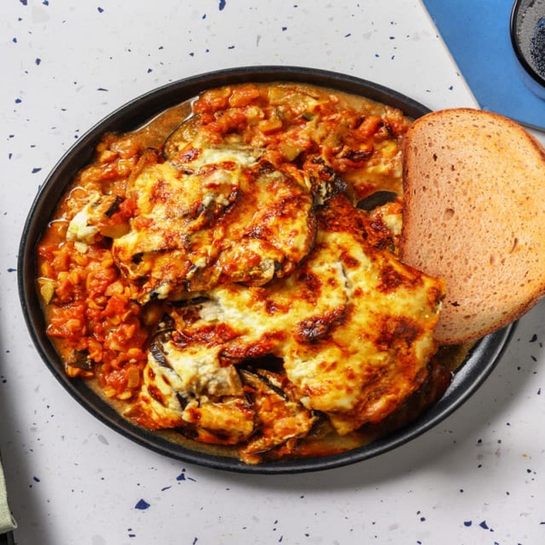 Moussaka veggie à la grecque & pain à l'ail avec des lentilles corail & de l'aubergine