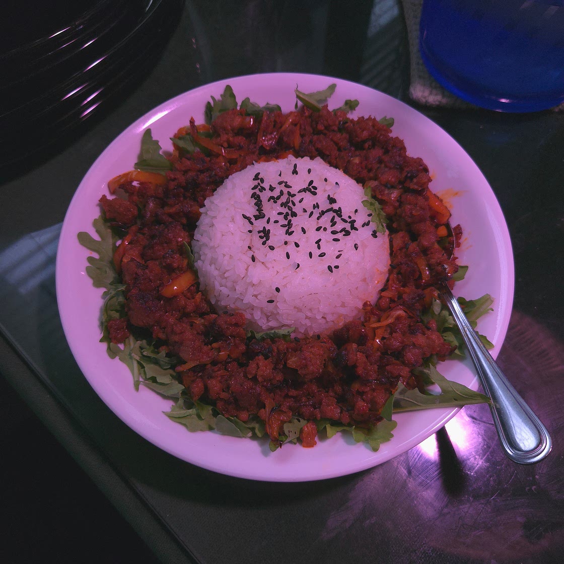 Gochujang stir fry with steamed rice over arugula