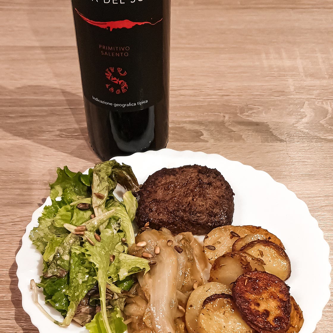 Steak haché au chicon caramélisé avec tranches de pommes de terre et salade fraîche