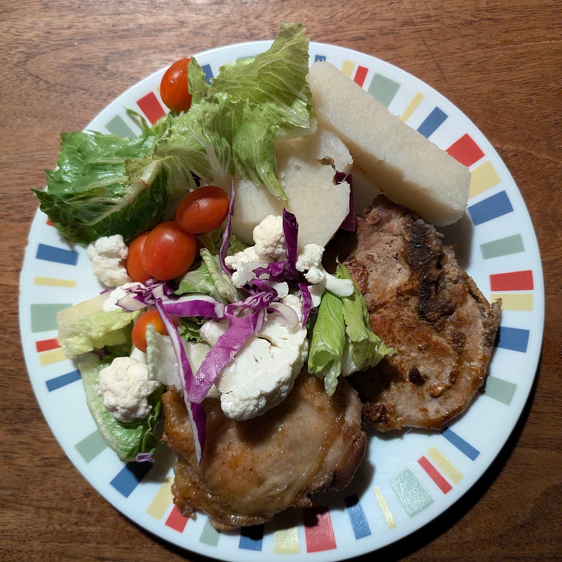 Pork chop, chicken thigh, and yam with lettuce, cauliflower, purple onion, and baby tomatoes