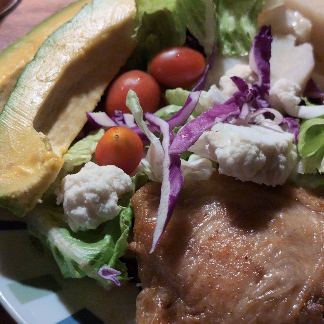 Pork chop, chicken thigh, and yam with lettuce, cauliflower, purple onion, and baby tomatoes