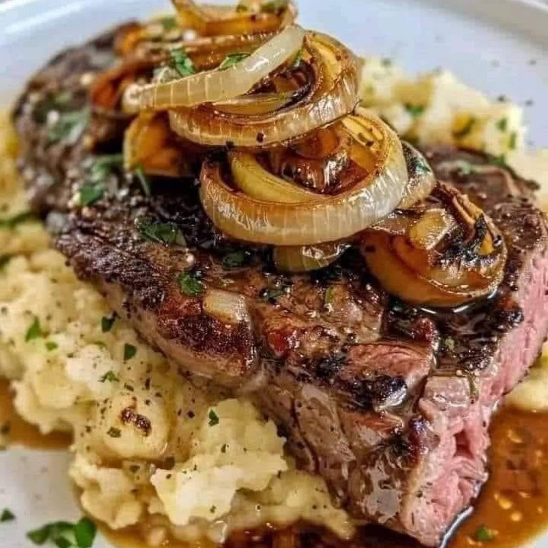 Ribeye steak with caramelised onions and mashed potatoes