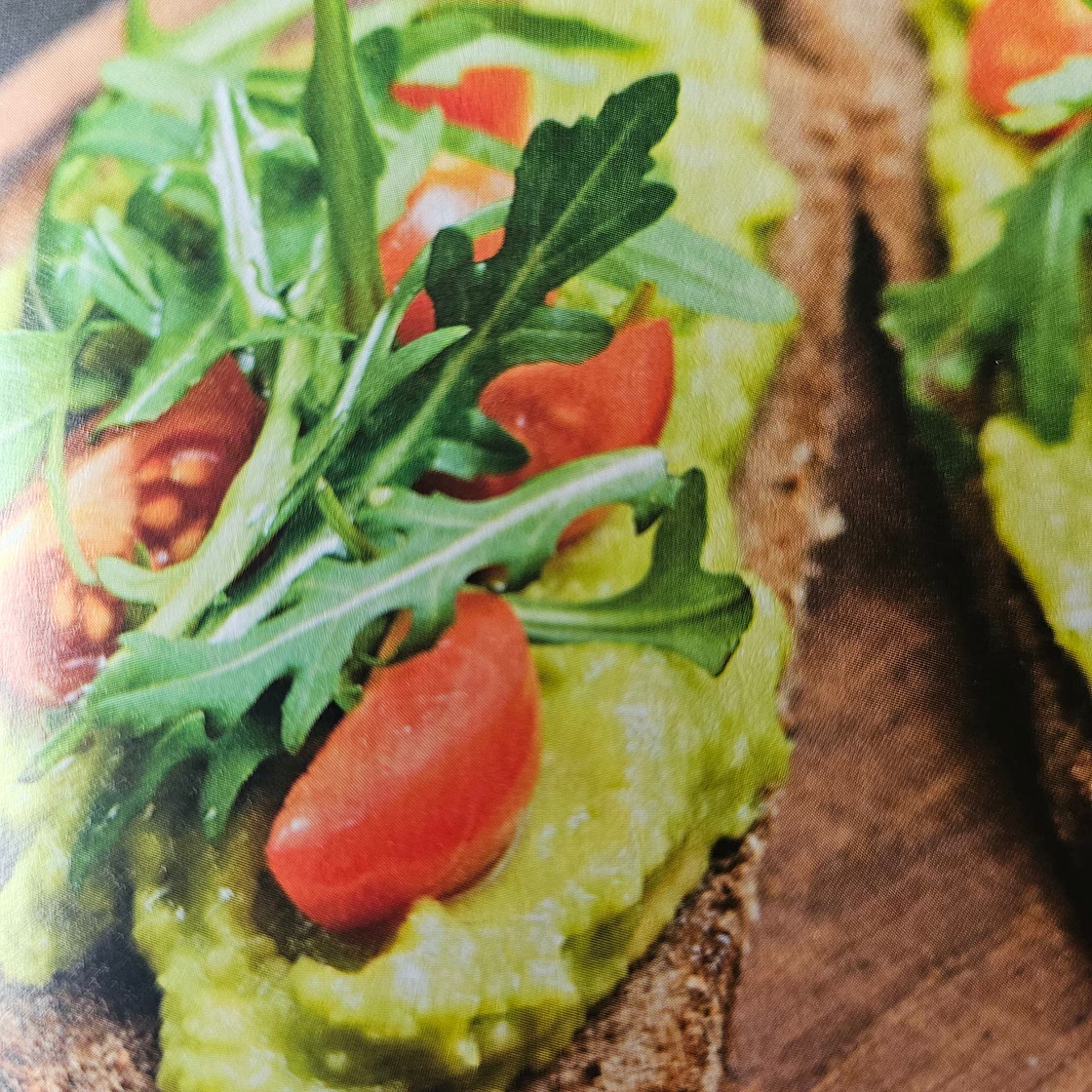 Avocado auf Toast mit Tomaten und Rucola