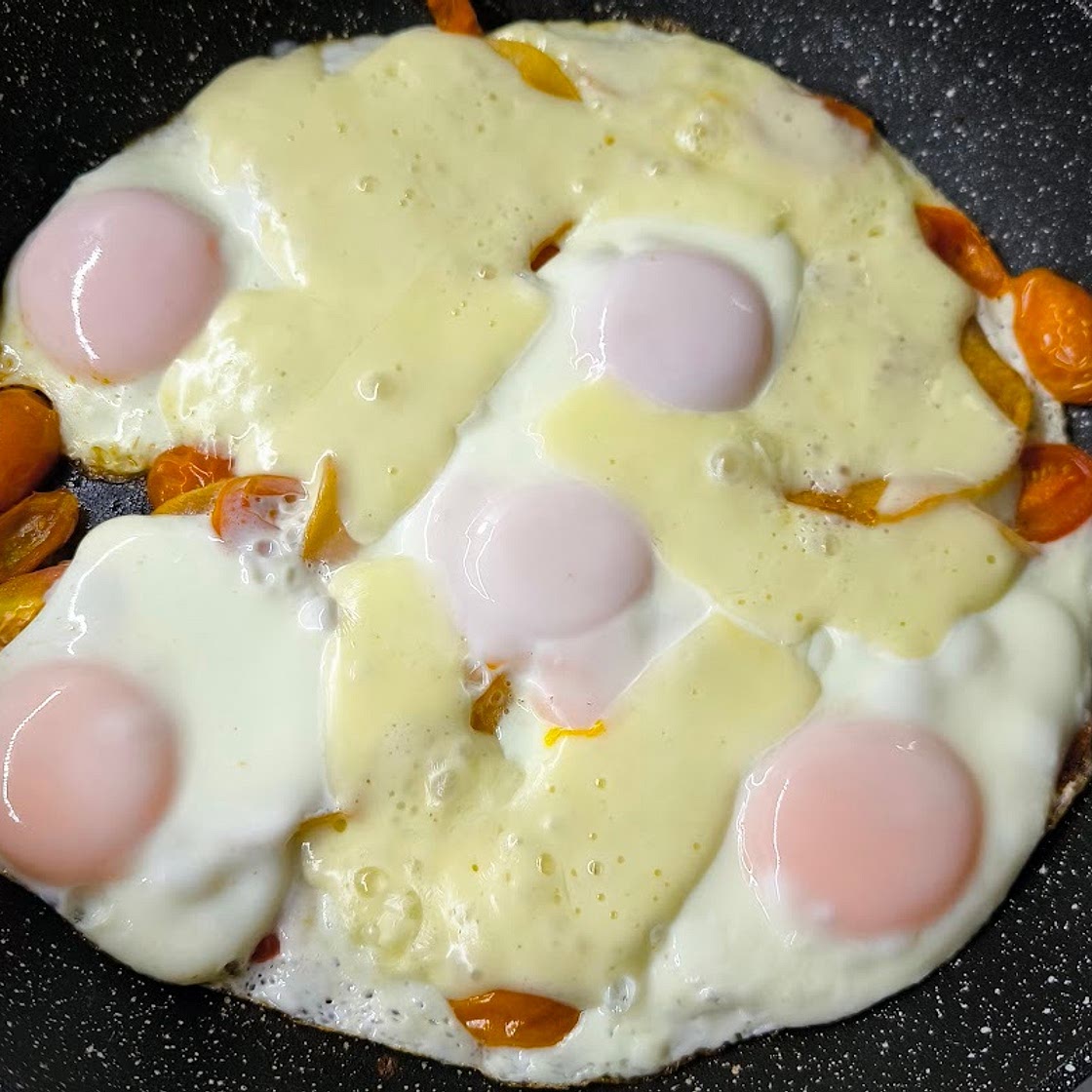 Scrambled eggs with tomatoes, meat, and cheese