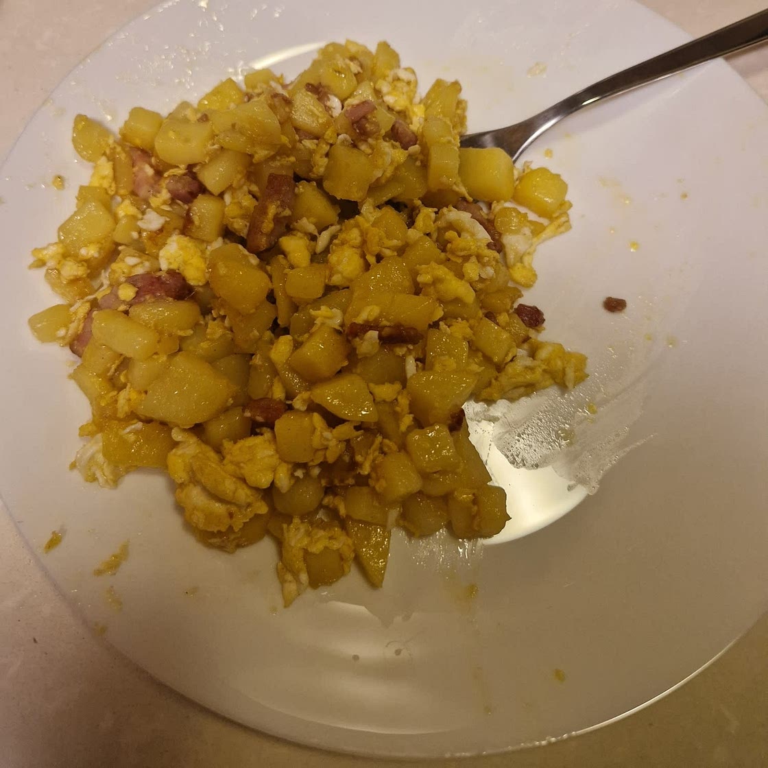 Patate in padella con uova e bacon