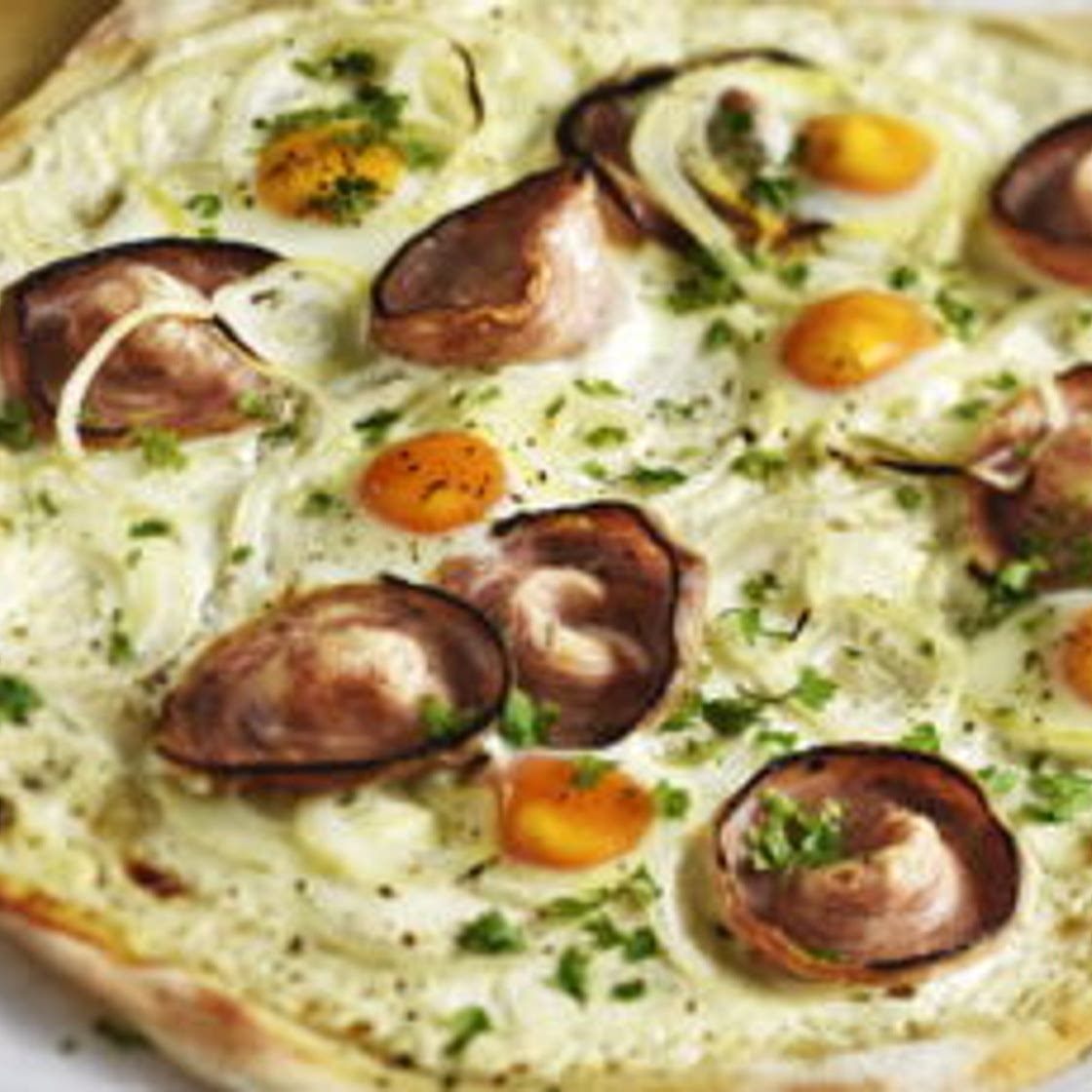 Pizza à la crème fraîche andouille de Guémené œuf de caille et oignon de Roscoff