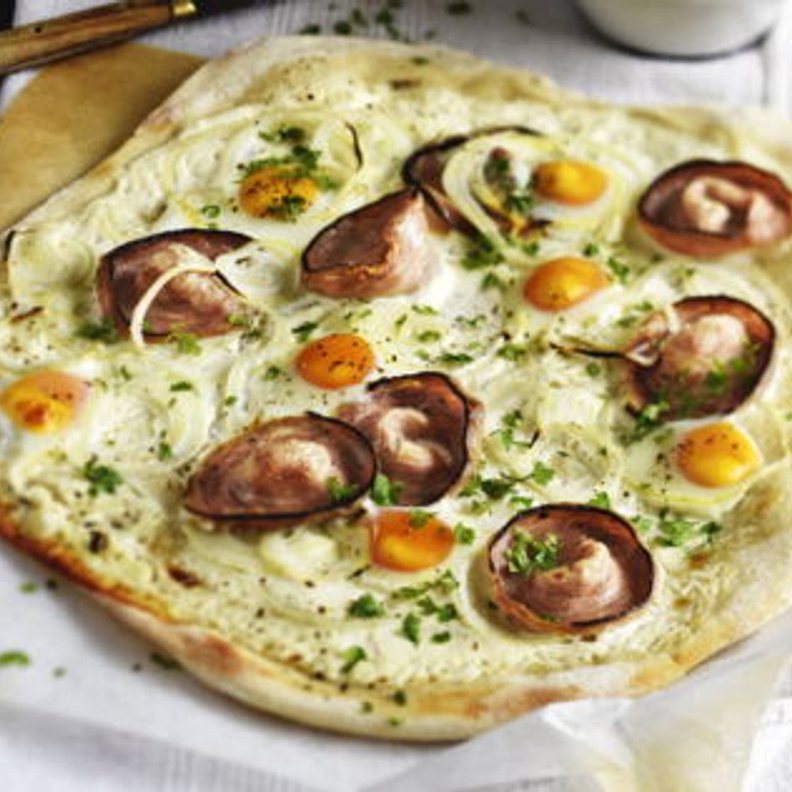 Pizza à la crème fraîche andouille de Guémené œuf de caille et oignon de Roscoff