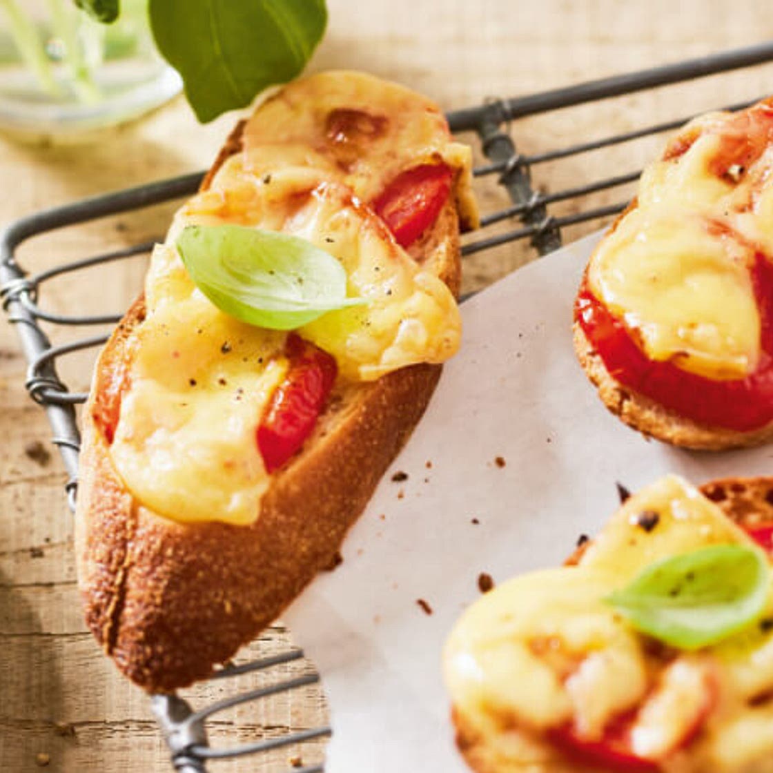 Überbackenes Brot mit Käse, Tomaten und Basilikum