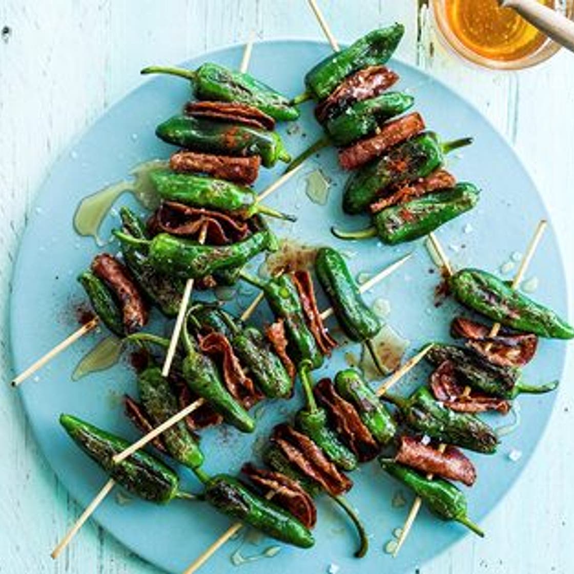 Grilled padron peppers and chorizo skewers with honey drizzle