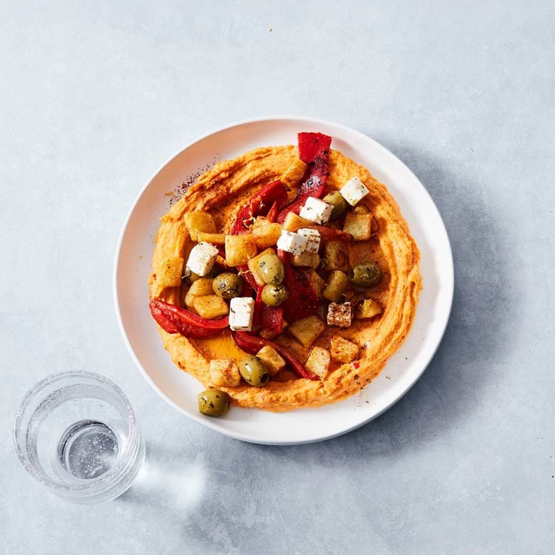 Pikante hummusbowl met aardappel en olijven