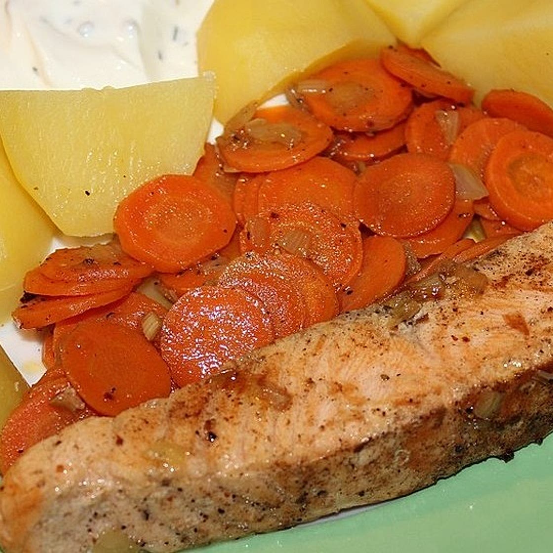 Lachsfilet mit gedünsteten Karotten und Zwiebeln