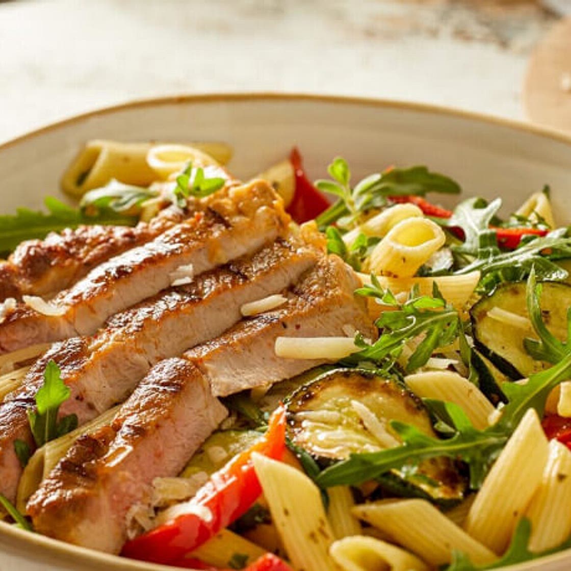 Nackensteaks mit mediterranem Nudelsalat und Rucola