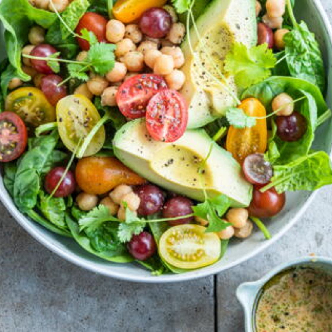 Salade d'été à l'avocat, pois chiches, raisins rouges et tomates cerises