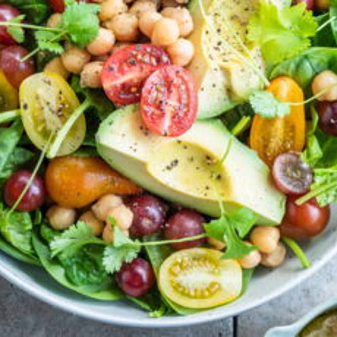 Salade d'été à l'avocat, pois chiches, raisins rouges et tomates cerises
