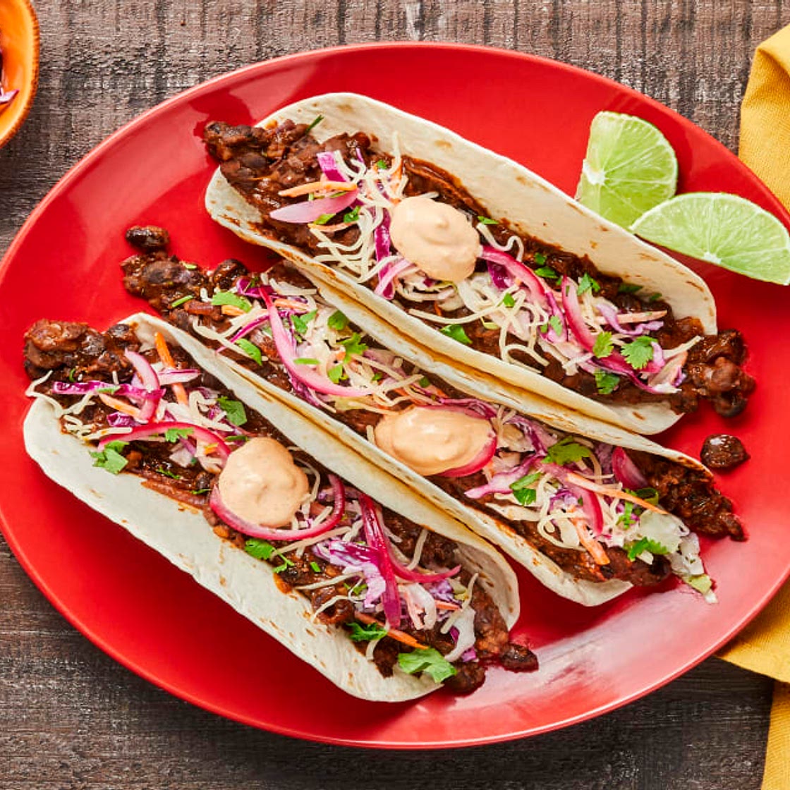 Smashed Black Bean Tacos with Creamy Slaw, Pickled Onion & Red Pepper Crema