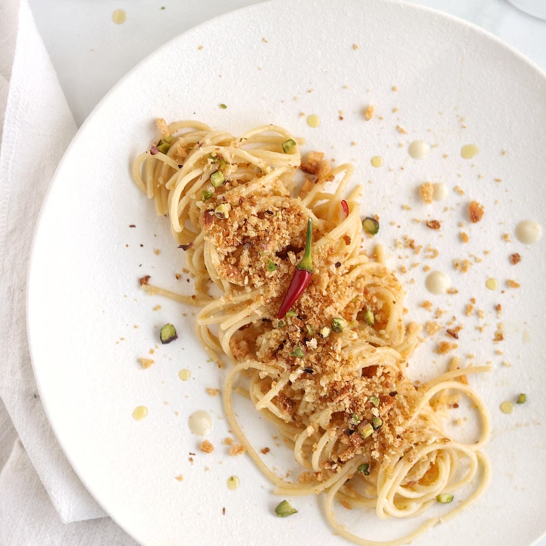 Spaghetti con crema di aglio, peperoncino e briciole croccanti