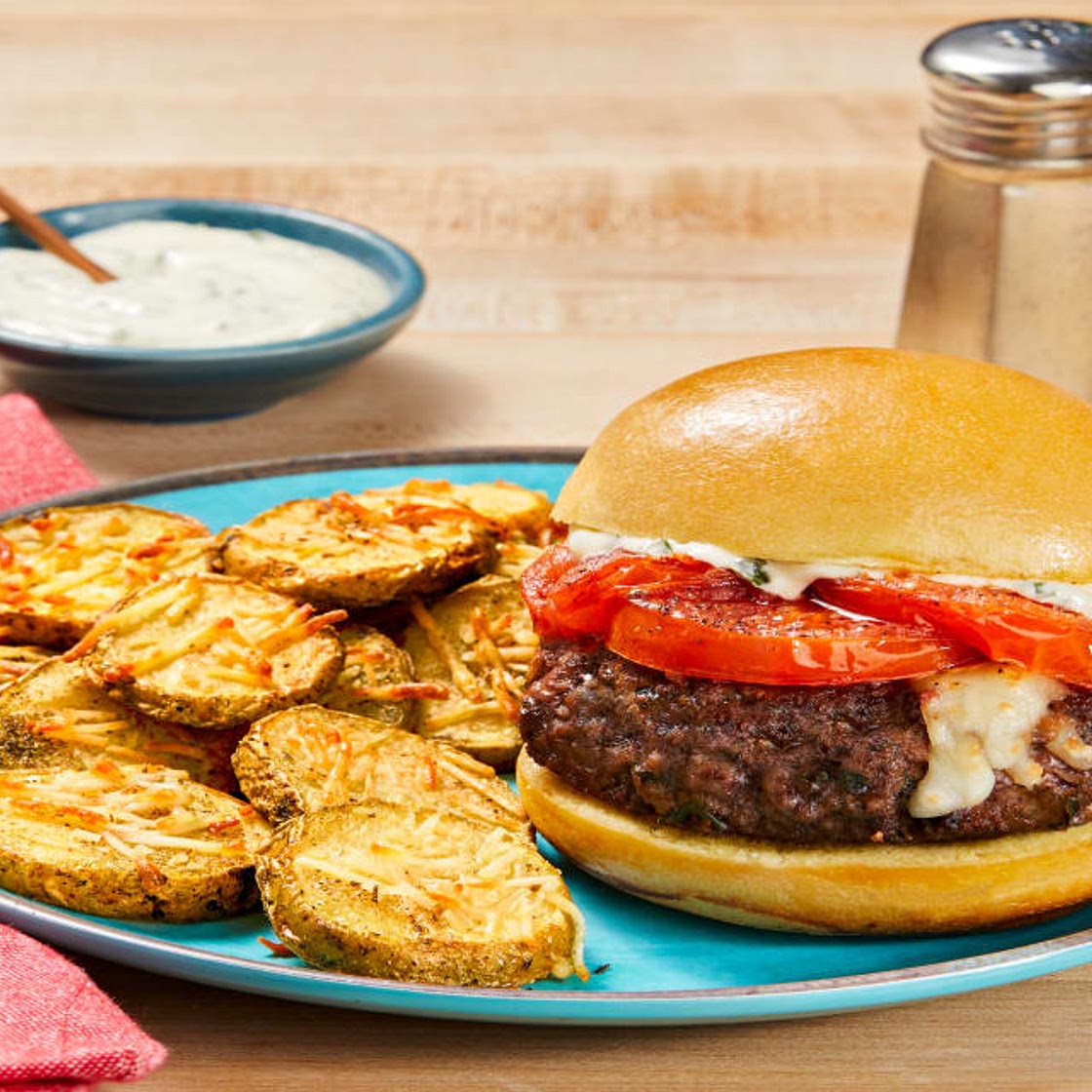 Mozz-Stuffed Caprese Burgers with Griddled Tomato, Basil Sauce & Parmesan Potato Rounds