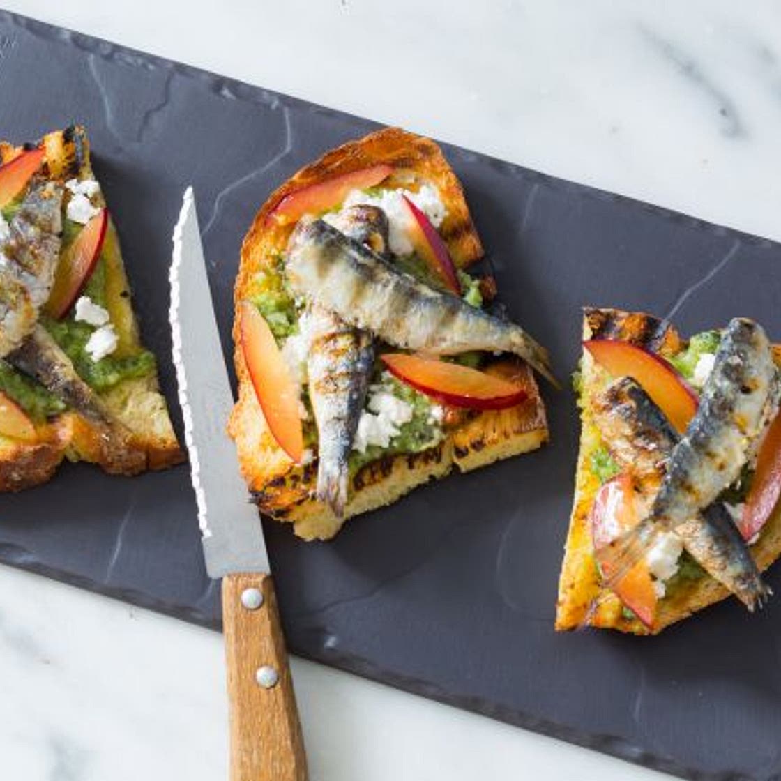 Bruschette al pesto di erbe e sardine grigliate