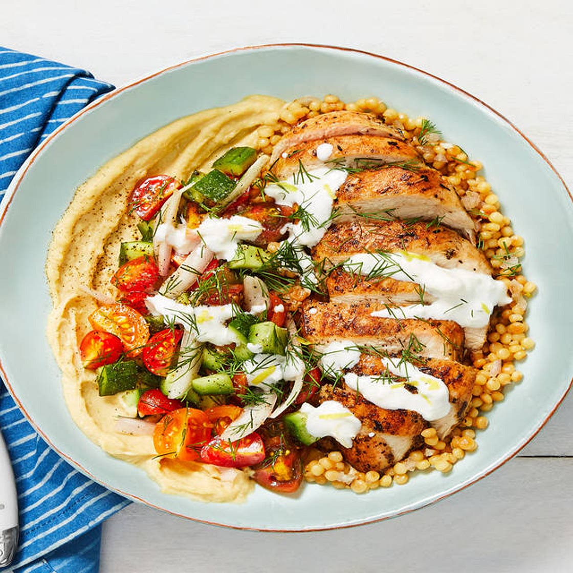 Chicken Gyro Couscous Bowls with Hummus, Tomato-Cucumber Salad, and Creamy Feta Sauce